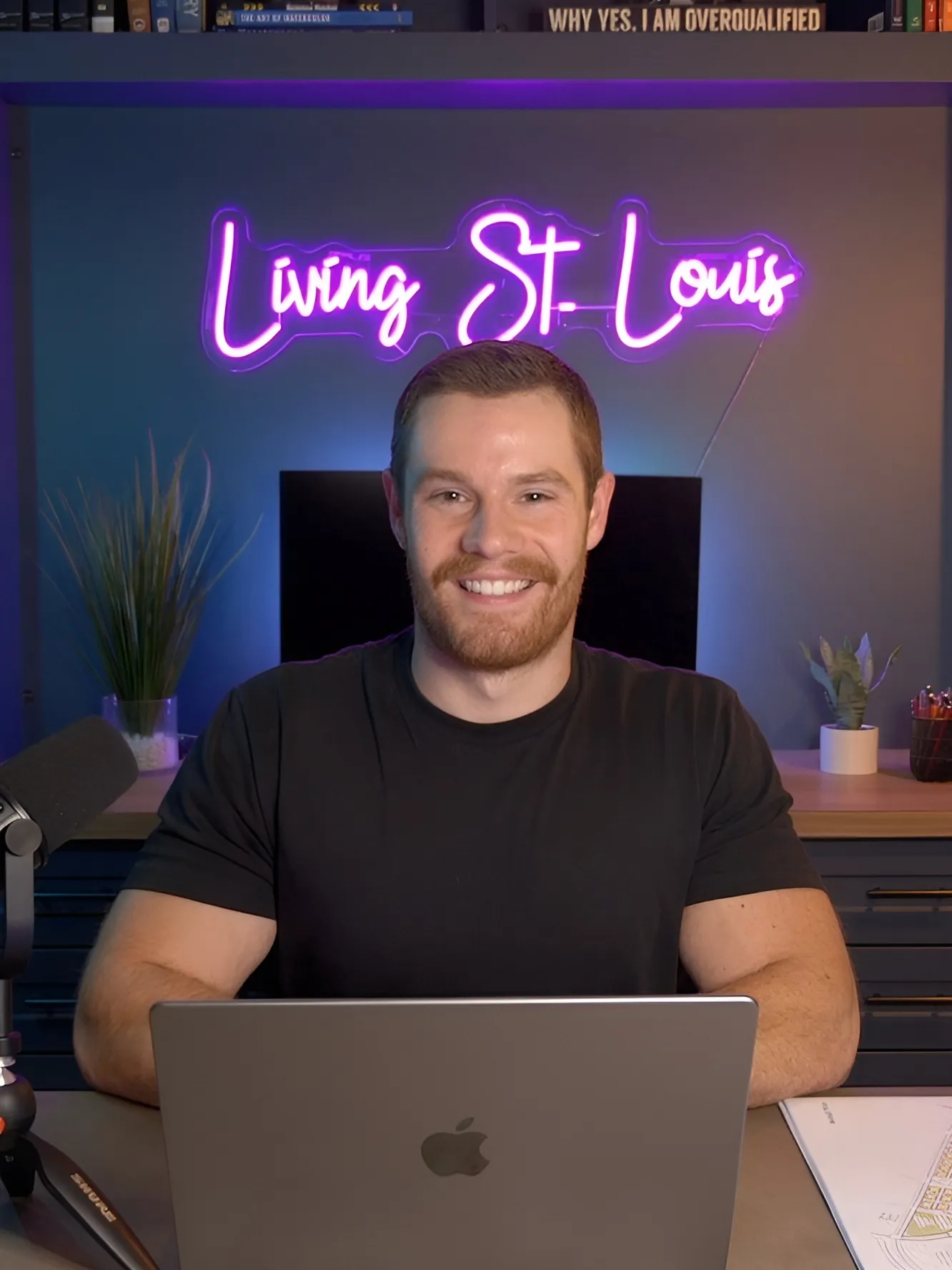 Jacob Peistrup at his desk under the Living St. Louis neon sign